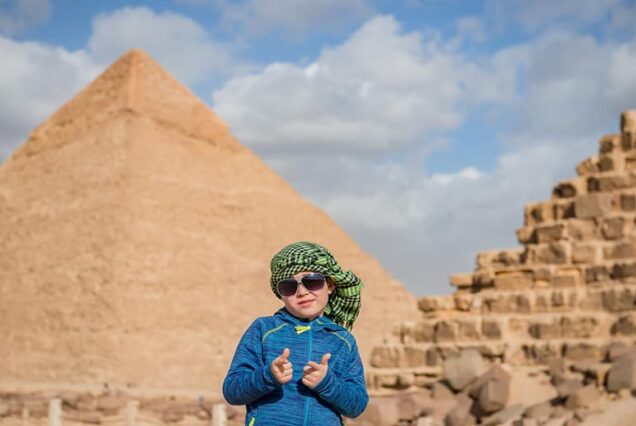 happy boy sunglasses standing front pyramides